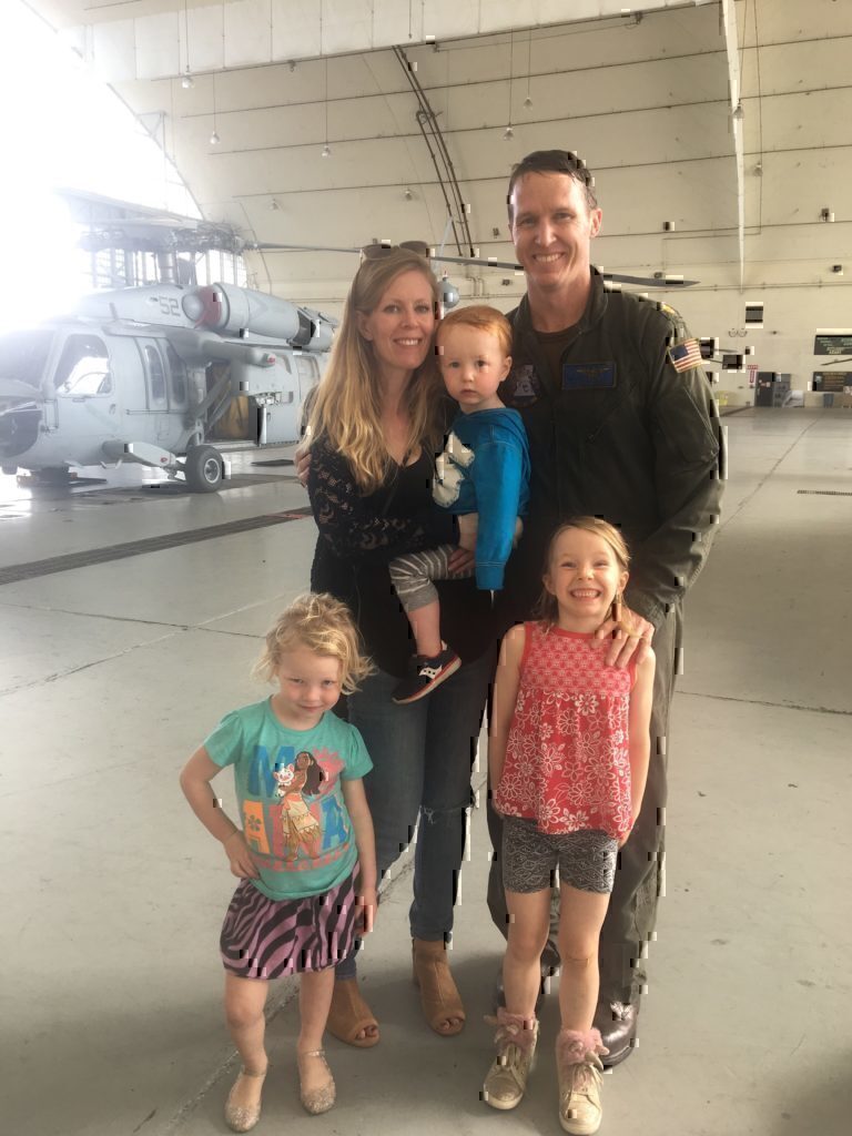 Jennifer Barnhill posing and smiling with her husband and three children.