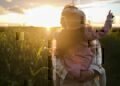 Mom holding a daughter in a field at sunset thinking about planning her estate