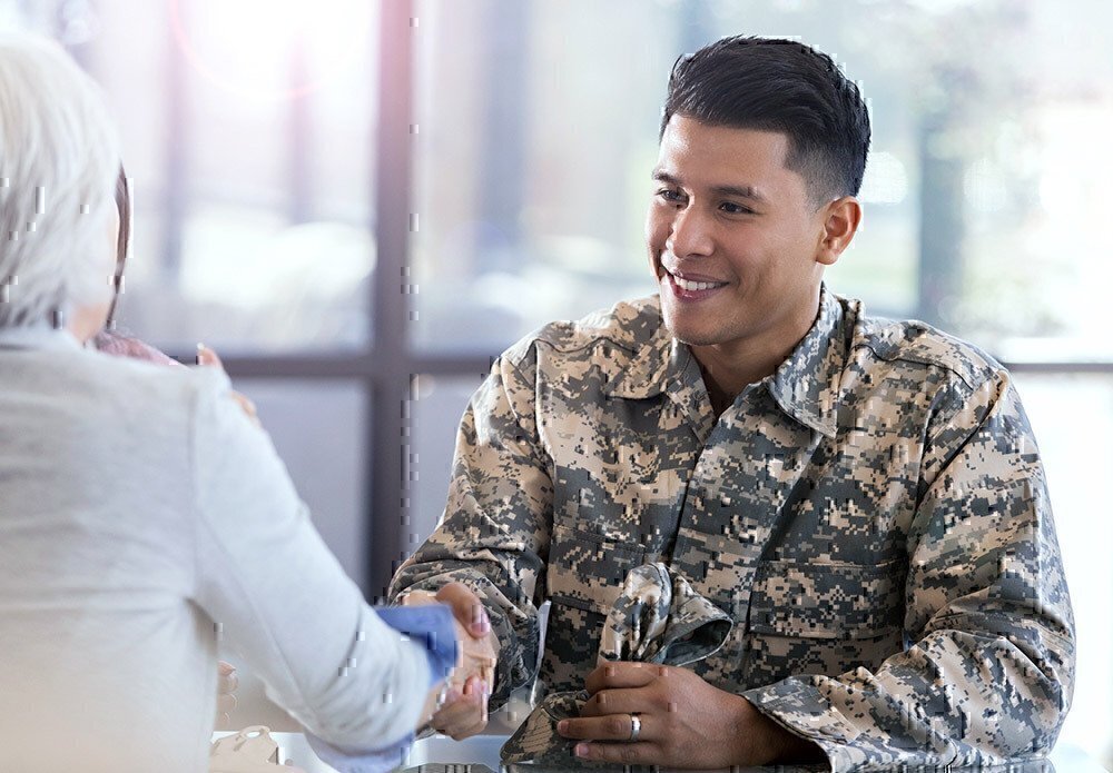 Service member shaking the hand of a training leader.