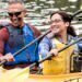 Two healthy couples who use Blue Cross Blue Shield for their vision insurance are paddling down the river in a kayak.